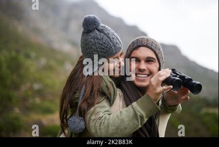 En prenant la vue comme la randonnée jusqu'au sommet. Un jeune couple prend dans tous les paysages tout en appréciant une randonnée en montagne. Banque D'Images