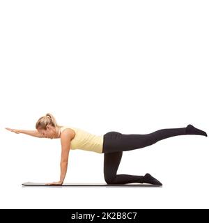 Expérience de l'exercice. Une jeune femme en forme qui s'étire et s'entraîner sur son tapis d'exercice. Banque D'Images