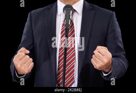 Vous pouvez sentir sa passion. Vue rognée d'un homme en costume parlant dans un microphone avec ses mains dans les poings. Banque D'Images