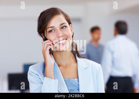 Jeune femme cadre parlant au bureau de téléphone portable. Gros plan de la jeune femme cadre parlant sur téléphone mobile avec le personnel en arrière-plan. Banque D'Images