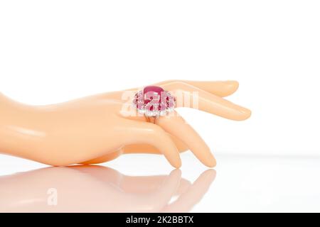 Rubis saphir avec anneau de diamants sur main femelle de mannequin en plastique. Collection d'accessoires en pierres précieuses naturelles. Prise de vue en studio Banque D'Images