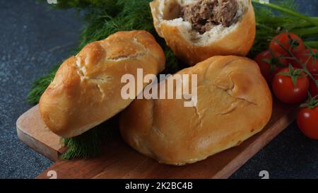 Patties ukrainiennes (Pasties, gâteaux chauds, Pirozhki, tartes) sur une assiette. Tartes maison traditionnelles à la viande Banque D'Images