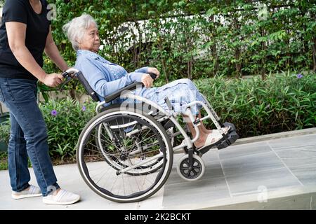 Aide-soignant et soins asiatique senior ou âgée vieille femme patiente assise en fauteuil roulant dans le service hospitalier de soins infirmiers, concept médical sain et fort Banque D'Images