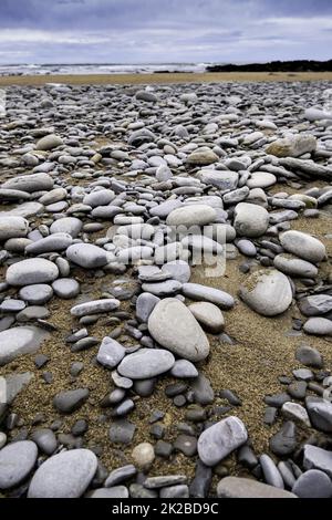 Pierres sur une plage de sable Banque D'Images