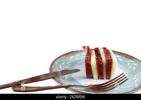 Guava sweet and curd cheese slices next to cutlery white background. Stock Photo