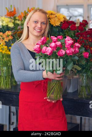 Je suis un maître fleuriste. Une coupe courte d'une femme debout avec un bouquet de fleurs. Banque D'Images