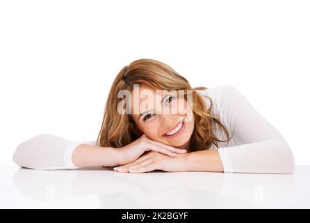 Beauté saine sourire en dessous de copyspace. Une magnifique jeune femme couchée sur un sol blanc et souriant magnifiquement. Banque D'Images