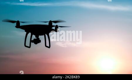 Silhouette Quadrocopters contre l'arrière-plan de la coucher du soleil Banque D'Images