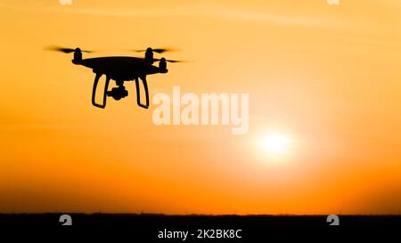 Silhouette Quadrocopters contre l'arrière-plan de la coucher du soleil Banque D'Images