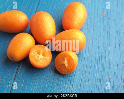 Des kumquats frais biologiques sur une table de cuisine rustique en bois Banque D'Images