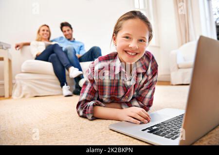 Elle se divertit partout. Les grands-parents regardent leur petite-fille à l'aide d'un ordinateur portable. Banque D'Images