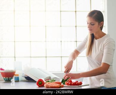 Il s'agit de préparer des repas sains et sains. Prise de vue d'une jeune femme préparant un repas sain à la maison. Banque D'Images