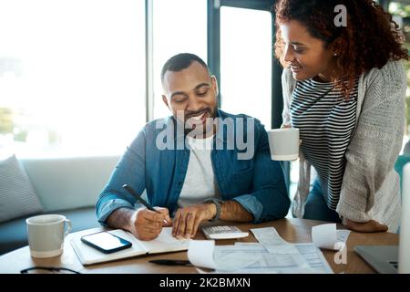 Permettez-moi de vous montrer comment nous pouvons économiser encore plus. Photo d'un jeune couple planifiant son budget ensemble à la maison. Banque D'Images