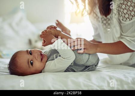 Le sourire d'un enfant est la vue la plus précieuse. Photo d'une mère méconnue et de son adorable bébé garçon jouant ensemble à la maison. Banque D'Images