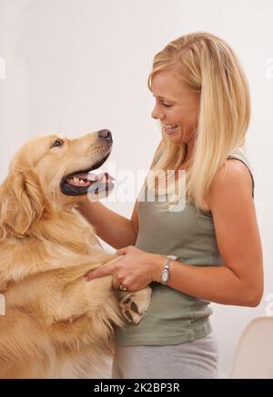 Bienvenue chez vous - IVE vous a manqué. Photo d'une jeune femme attrayante en interaction avec son chien. Banque D'Images