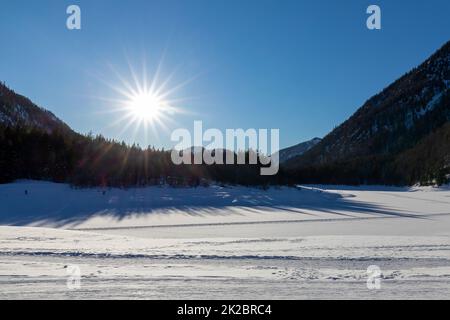 Soleil sur le lac gelé Loedensee près de Ruhpolding, Bavière, Allemagne Banque D'Images