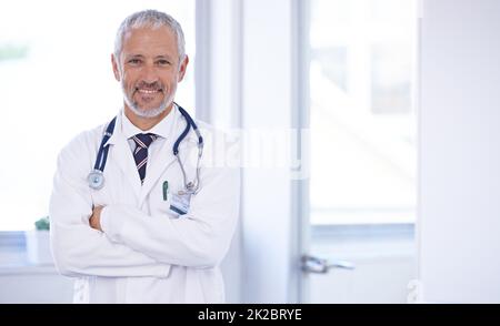 Le médecin de famille de confiance. Portrait d'un médecin debout dans une pièce bien éclairée avec ses bras croisés. Banque D'Images