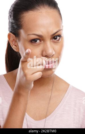 Je n'y suis pas. Photo courte d'une jeune femme en colère pointant un doigt vers l'appareil photo. Banque D'Images