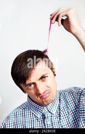C'est une situation collante. Portrait d'un homme mécontent avec du bubblegum dans ses cheveux. Banque D'Images