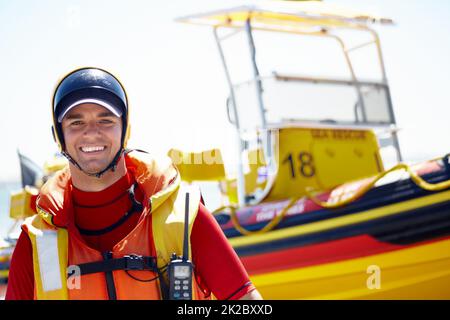 J'aime le sauvetage en mer. Portrait court d'un beau jeune homme maître de sauvetage se préparant à sortir en mer lors d'une mission de sauvetage. Banque D'Images