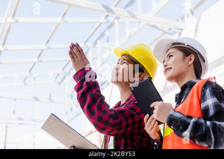 Homme et femme de contremaître d'ingénieur asiatique travaillant sur le chantier de construction de bâtiments Banque D'Images