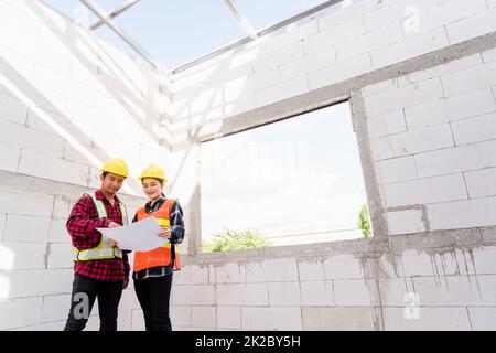 Architecte et client discutant du plan avec le plan du bâtiment sur le chantier de construction Banque D'Images