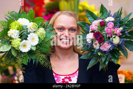 Ce sont mes chefs-d'œuvre. Une coupe courte d'une femme debout avec un bouquet de fleurs. Banque D'Images