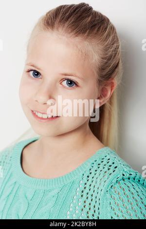 Vous donner un sourire. Portrait d'une jeune fille confiante debout dans le studio. Banque D'Images