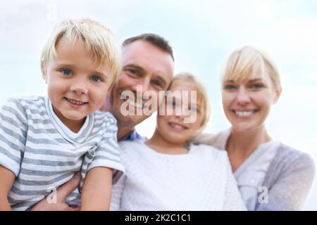 C'est une famille si heureuse. Une famille heureuse de deux générations souriant à l'extérieur. Banque D'Images