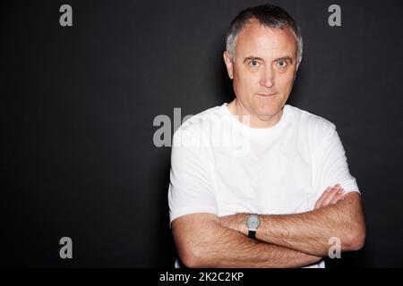 Devenir plus sérieux avec l'âge. Studio portrait d'un homme mature isolé sur noir. Banque D'Images