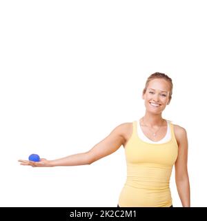 En tenant sa balle de stress. Vue rognée d'une femme qui exerce une pression sur un ballon de stress sur un fond blanc. Banque D'Images