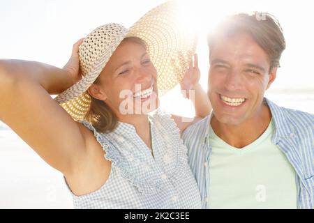 Bonheur au soleil. Un couple heureux en train de rire sur la plage. Banque D'Images