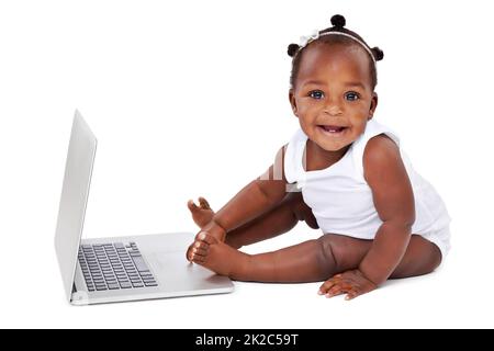 Le remède à l'ennui est curiousité. Studio photo d'une adorable petite fille à l'aide d'un ordinateur portable isolé sur blanc. Banque D'Images