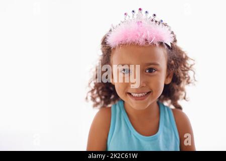 Shes juste une petite princesse. Studio portrait d'une adorable petite fille dans un tiara isolé sur blanc. Banque D'Images