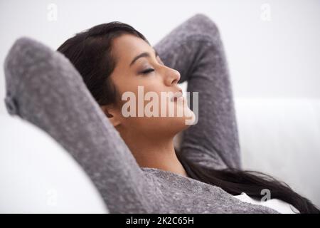 Faire une pause. Une jeune femme qui prend une sieste sur son canapé. Banque D'Images