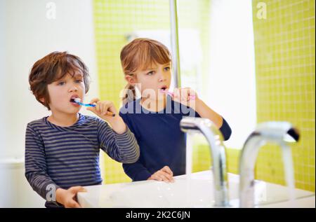 La théyre a bien enseigné. Photo d'un frère et d'une sœur se brossant les dents à la maison. Banque D'Images