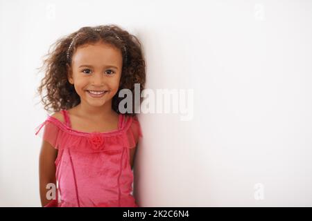 Je suis une princesse de fées. Portrait d'une petite fille dans une robe rose souriant à l'appareil photo. Banque D'Images