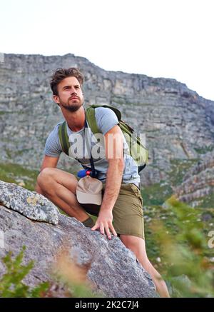 Il sait où il va. Photo d'un beau jeune homme qui escalade une montagne. Banque D'Images