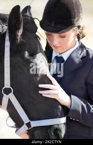 HES plus qu'un animal pour moi. Photo d'une belle jeune femme debout à côté de son cheval. Banque D'Images