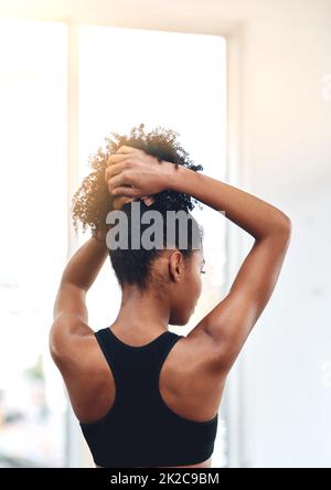 Mettez vos cheveux et réessayez. Vue arrière d'une jeune femme tenant ses cheveux. Banque D'Images