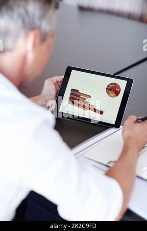 Examiner le bien-être financier des entreprises. Photo rognée d'un homme d'affaires regardant des graphiques sur une tablette numérique dans un bureau. Banque D'Images