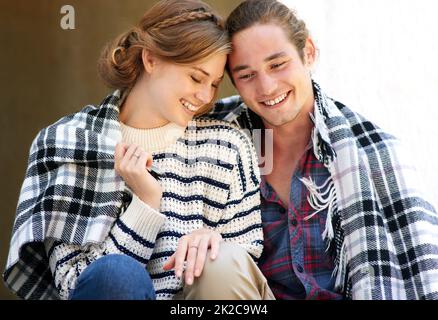 Un jeune couple s'est enveloppé dans une couverture Banque D'Images