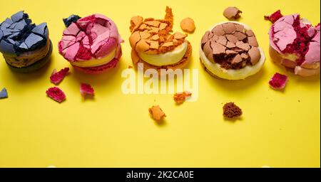 macarons ronds cassés avec chapelure sur fond jaune, délicieux dessert, vue de dessus Banque D'Images