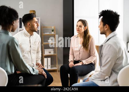 Les gens à l'écoute de la jeune femme qui parle de ses problèmes Banque D'Images