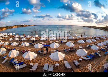 Des rangées de transats et de parasols sur une plage de Coral Bay près du village de Peia. Banque D'Images