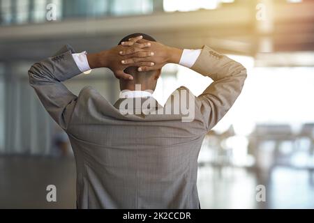 Les affaires sont le produit d'une pression unique. Vue arrière d'un homme d'affaires debout avec ses mains derrière sa tête. Banque D'Images