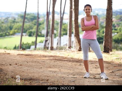 Elle aime l'extérieur. Une jolie jeune femme en sport s'exerçant dans la forêt. Banque D'Images