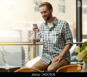 HES a obtenu toutes les connexions. Prise de vue d'un jeune homme utilisant un téléphone portable dans un café. Banque D'Images