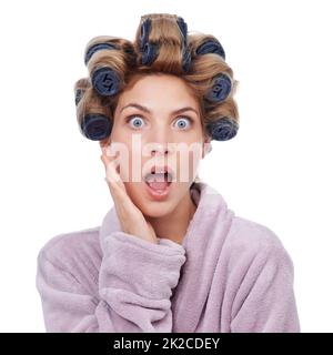 Faire du joli. Photo studio d'une femme dans un peignoir et des curlers. Banque D'Images