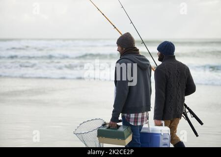 Emballé et prêt à pêcher. Photo d'un deux amis qui pêchent tôt le matin. Banque D'Images